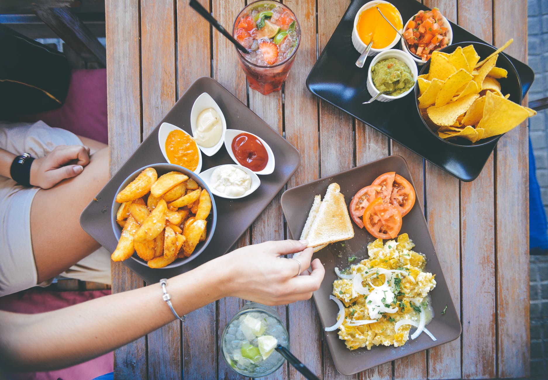 Image of nachos and other dishes being shared